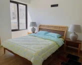 تخت خواب با روتختی آبی و پنجره ی رو به خیابان اتاق خواب آپارتمان در رامسر 54125