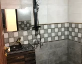 حمام با سنگ کاری مشکی سفید و شیرآلات فلزی آپارتمان اوشیان 45588444