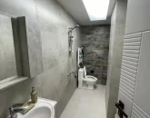 حمام و سرویس بهداشتی با سنگ کاری طوسی و روشویی سفید آپارتمان جواهر ده 1122555