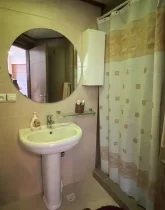 روشویی و آیینه و پرده در سرویس بهداشتی آپارتمان در چابکسر