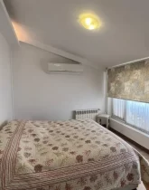 تخت خواب با روتختی سفید و صورتی و پرده ی حریر سفید و کرمی آپارتمان در چابکسر