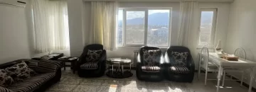 مبلمان راحتی مشکی رنگ و فرش کرمی با پنجره های رو به ویلاهای اطراف سالن نشیمن آپارتمان در سادات شهر 564165